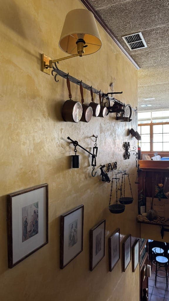 Detalles rústicos, cacerolas de cobre y balanzas en la pared