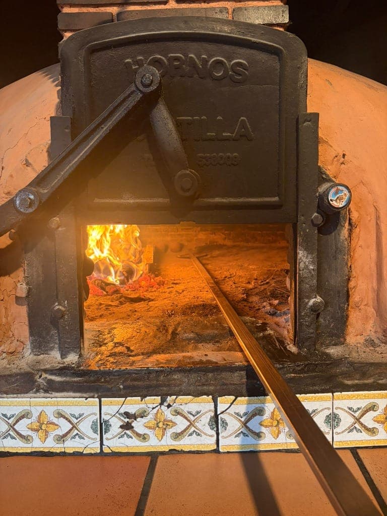 Boca del horno Hornos Castilla con puerta de hierro fundido y pala tradicional